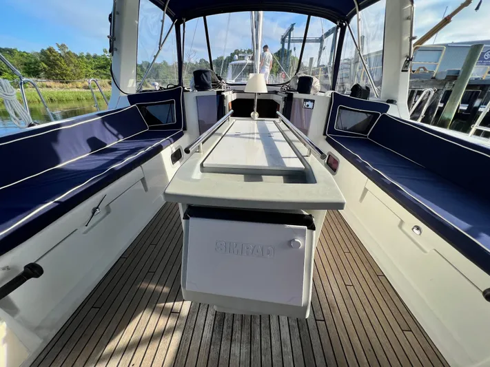 Serendipity Yacht Photos Pics Spacious cockpit of 2013 Beneteau Oceanis 45 sailboat with blue seating and wooden deck.