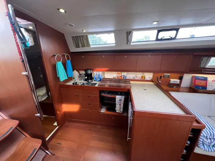 Serendipity Yacht Photos Pics Interior of 2013 Beneteau Oceanis 45 yacht kitchen with wooden cabinetry and modern appliances.