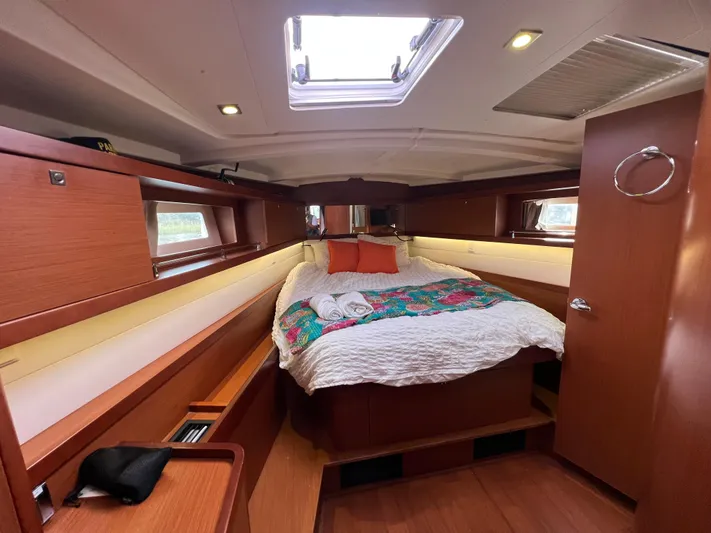 Serendipity Yacht Photos Pics Cozy cabin interior of 2013 Beneteau Oceanis 45 sailboat with bed and wooden furnishings.