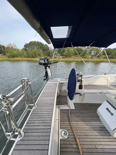Serendipity Yacht Photos Pics 2013 Beneteau Oceanis 45 sailboat deck with canopy, docked by a serene waterway.
