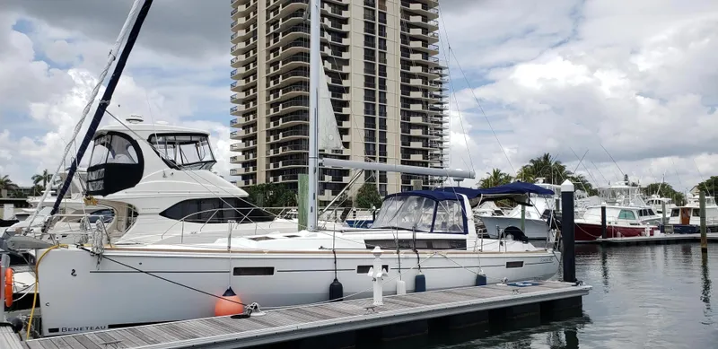 Serendipity Yacht Photos Pics 2013 Beneteau Oceanis 45 yacht docked at marina with high-rise building in background.