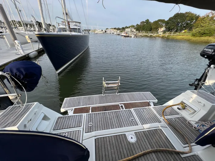 Serendipity Yacht Photos Pics Beneteau Oceanis 45 yacht stern view at marina, 2013 model, with wooden deck and water access.