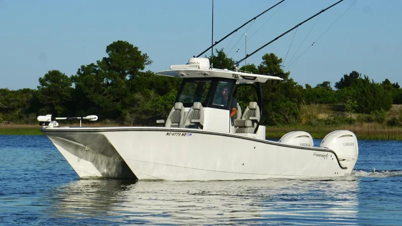  Yacht Photos Pics 2024 Freeman 28 boat cruising on calm water with trees in the background.