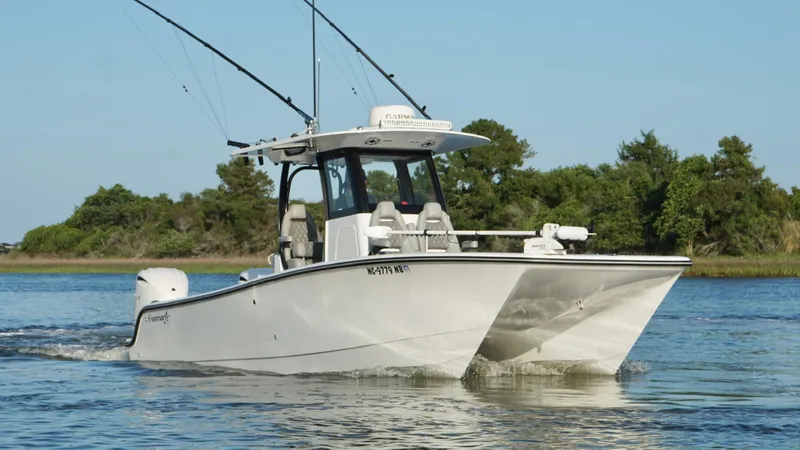  Yacht Photos Pics 2024 Freeman 28 boat cruising on a calm river with lush greenery in the background.
