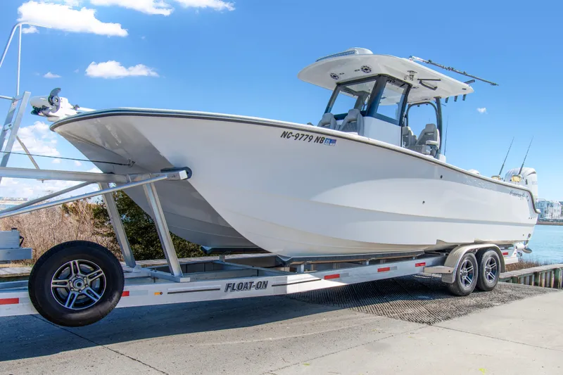  Yacht Photos Pics 2024 Freeman 28 boat on trailer, dockside under clear blue sky.