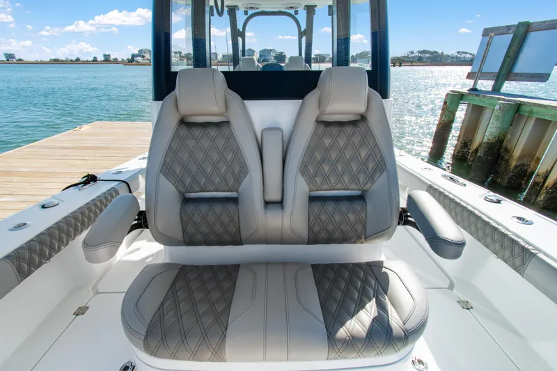  Yacht Photos Pics Luxury seating on 2024 Freeman 28 boat, docked by serene waters.