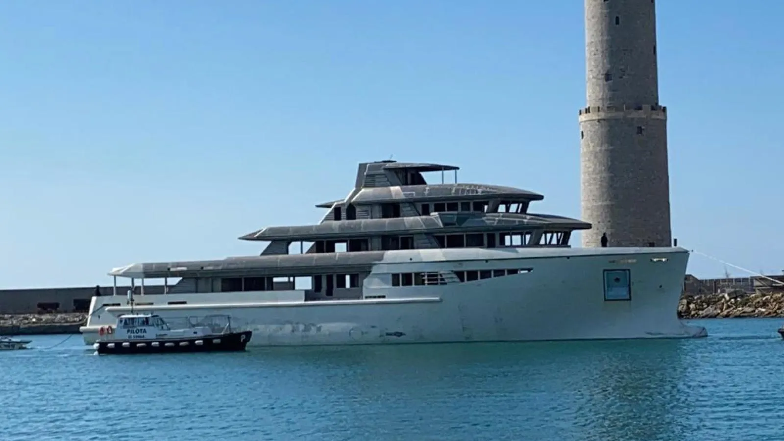 Luxurious custom yacht near a lighthouse, 2026 model, on a clear day.