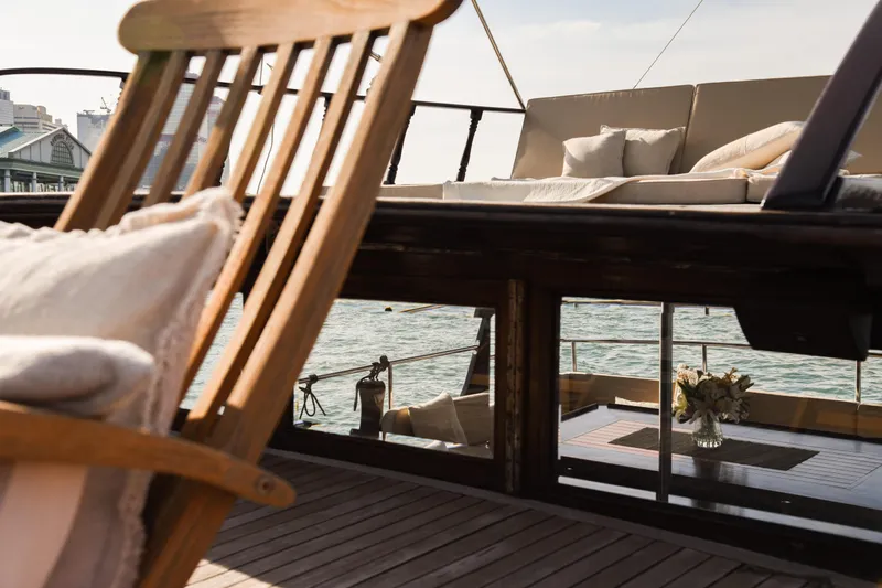 Gaiole Yacht Photos Pics Luxurious deck of 1994 Custom Junk boat with wooden chair and cushions.