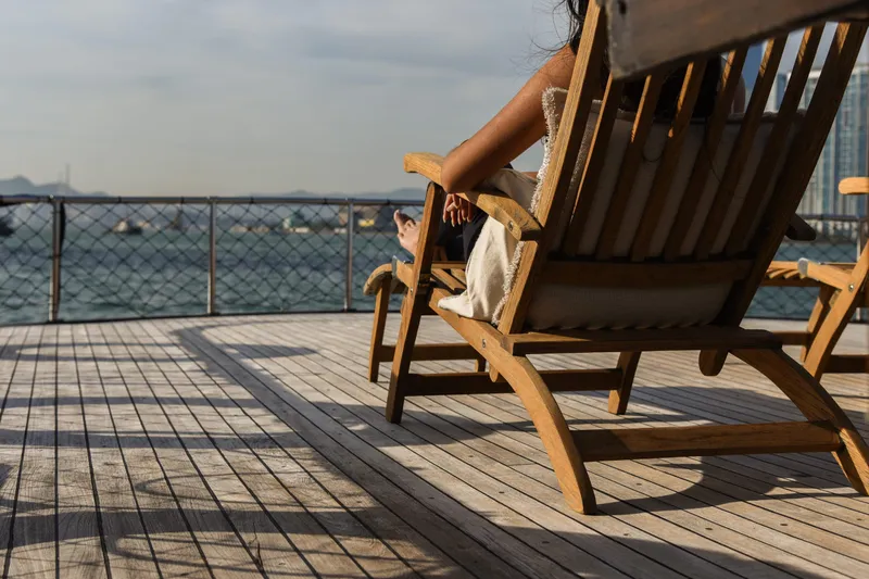 Gaiole Yacht Photos Pics Person relaxing on a wooden deck chair overlooking the ocean, Custom Junk 1994.