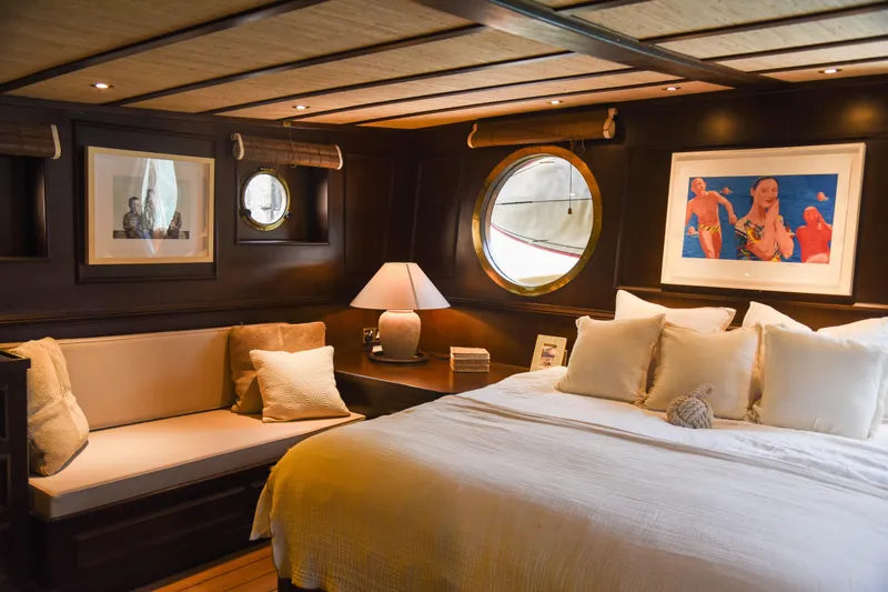 Gaiole Yacht Photos Pics Luxurious yacht bedroom with porthole windows, cozy seating, and elegant decor.
