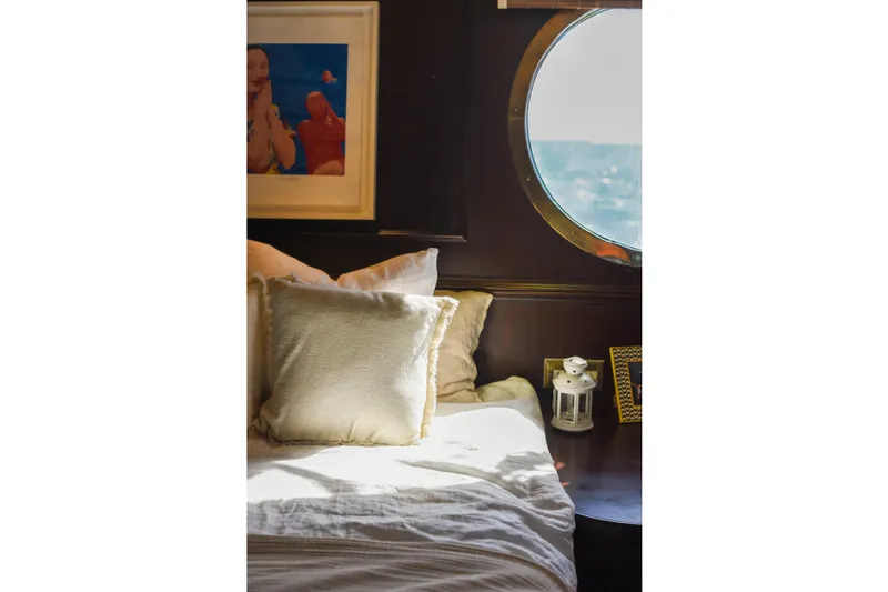 Gaiole Yacht Photos Pics Cozy bedroom with porthole window, soft pillows, and decorative lantern on a Custom Junk boat.