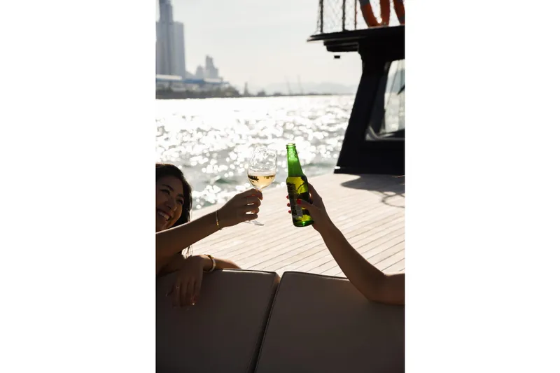 Gaiole Yacht Photos Pics People toasting with drinks on a boat, enjoying a sunny day on the water.