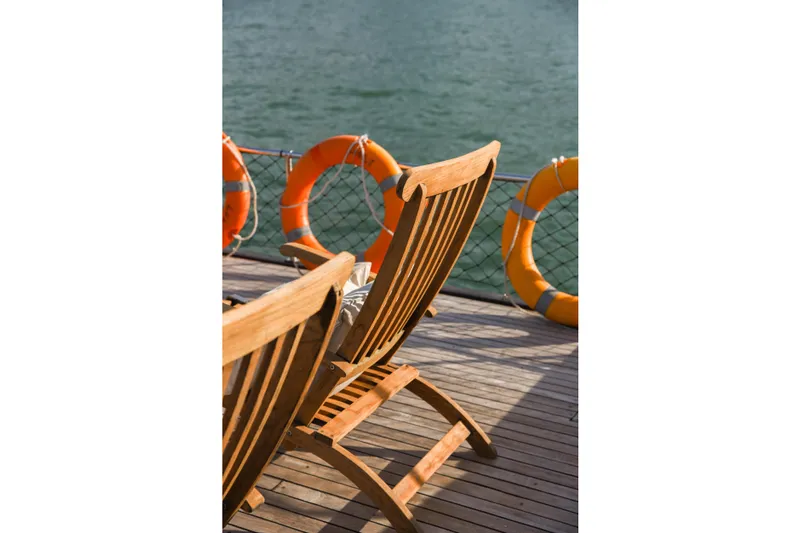 Gaiole Yacht Photos Pics Wooden deck chairs on a boat with lifebuoys, Custom Junk model, 1994.