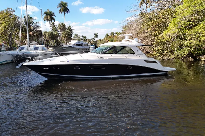  Yacht Photos Pics 2011 Sea Ray 450 Sundancer yacht cruising on a scenic waterway with palm trees.