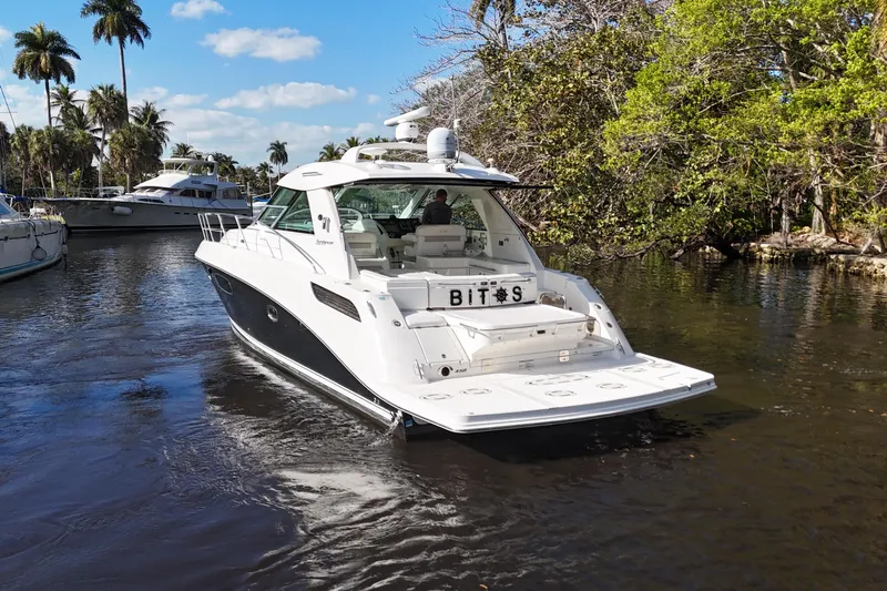  Yacht Photos Pics 2011 Sea Ray 450 Sundancer yacht cruising on a scenic waterway with lush greenery.