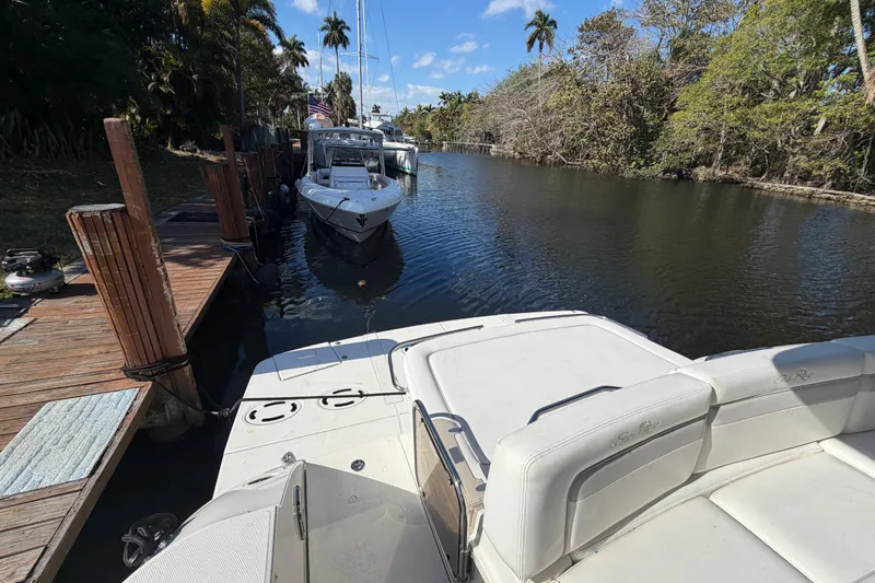  Yacht Photos Pics 2011 Sea Ray 450 Sundancer docked in a scenic canal with lush greenery.