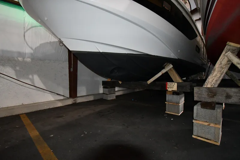  Yacht Photos Pics 2023 Beneteau Flyer 9 SUNdeck boat stored indoors on wooden supports.