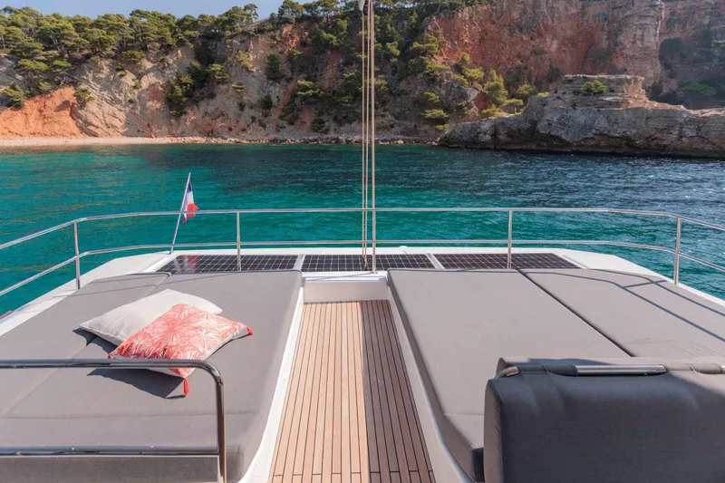  Yacht Photos Pics Luxurious 2025 Fountaine Pajot Samana 59 yacht with sunbathing deck, scenic coastal view.