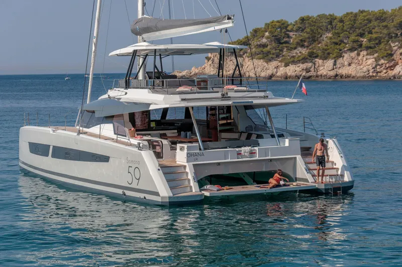  Yacht Photos Pics 2025 Fountaine Pajot Samana 59 yacht anchored in scenic coastal waters.