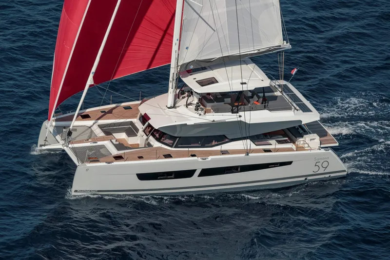  Yacht Photos Pics 2025 Fountaine Pajot Samana 59 catamaran sailing with red sails on open sea.