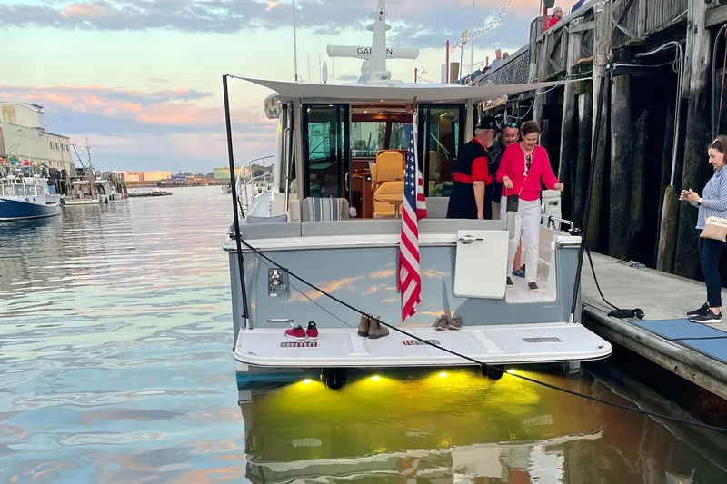  Yacht Photos Pics 2023 Sabre 43 Salon Express yacht docked at sunset with people on board.