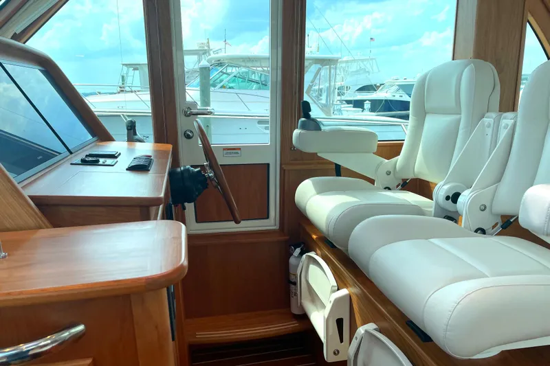 Yacht Photos Pics 2023 Sabre 43 Salon Express interior with white leather seats and wooden accents.
