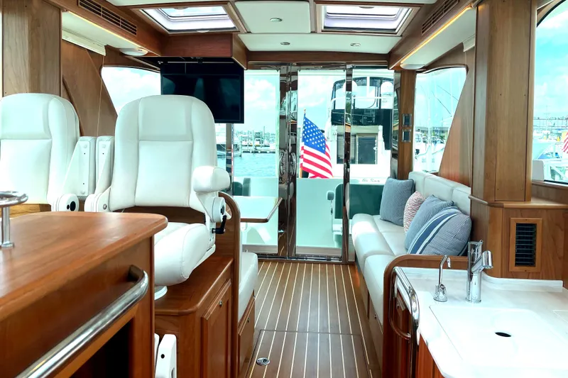  Yacht Photos Pics 2023 Sabre 43 Salon Express interior with luxurious seating and American flag view.