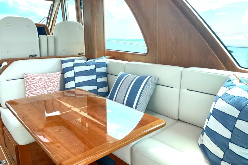  Yacht Photos Pics Luxurious interior of 2023 Sabre 43 Salon Express with striped cushions and wooden table.