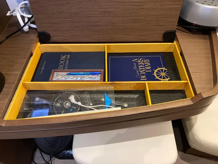 Vela Yacht Photos Pics Open drawer with books and navigation tools on a Lagoon 42, 2018 model.