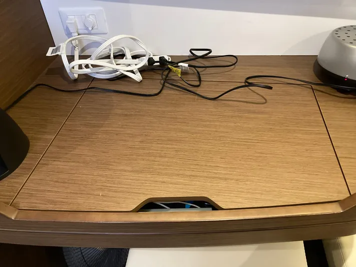 Vela Yacht Photos Pics Wooden desk with cables and electronic devices, inside a 2018 Lagoon 42 model.