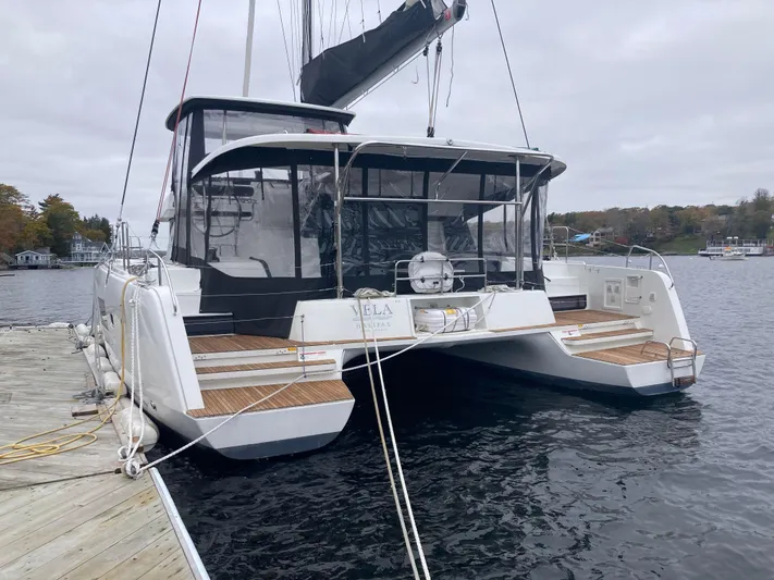 Vela Yacht Photos Pics 2018 Lagoon 42 catamaran docked at a marina, featuring a spacious deck and modern design.