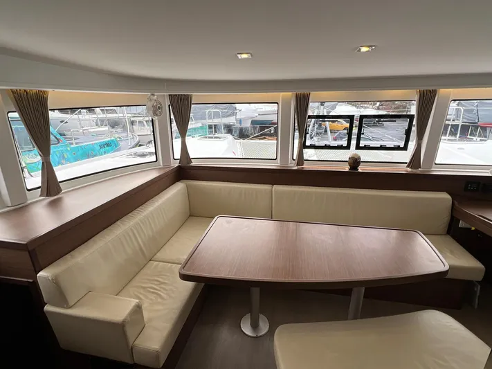 Vela Yacht Photos Pics Interior of 2018 Lagoon 42 yacht with beige seating and wooden table.