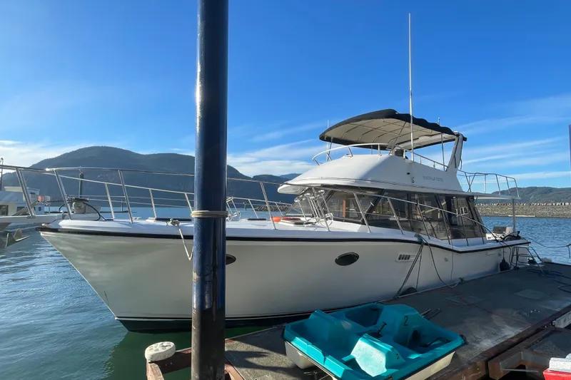 Hasta La Vista Yacht Photos Pics 1997 Symbol 48 Sportfish yacht docked with scenic mountain backdrop.