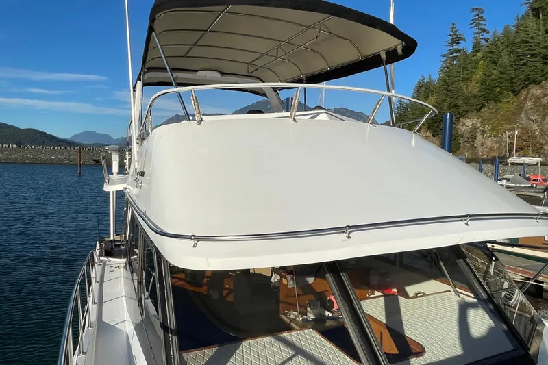 Hasta La Vista Yacht Photos Pics 1997 Symbol 48 Sportfish yacht docked in scenic marina with mountains.