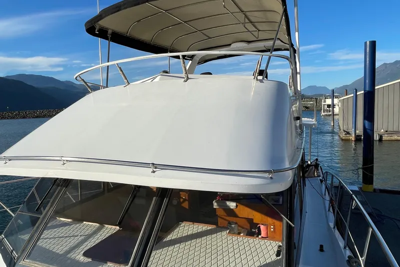 Hasta La Vista Yacht Photos Pics 1997 Symbol 48 Sportfish yacht docked with scenic mountain backdrop.