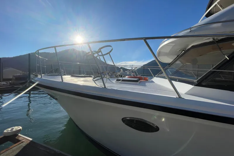 Hasta La Vista Yacht Photos Pics 1997 Symbol 48 Sportfish yacht docked under sunny skies with mountain backdrop.