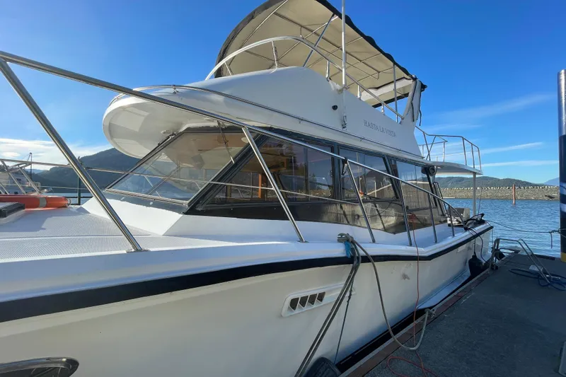 Hasta La Vista Yacht Photos Pics 1997 Symbol 48 Sportfish yacht docked, featuring sleek design and spacious upper deck.