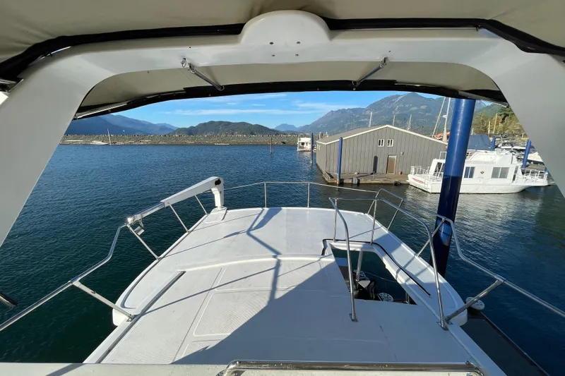 Hasta La Vista Yacht Photos Pics 1997 Symbol 48 Sportfish yacht docked at scenic marina with mountain views.