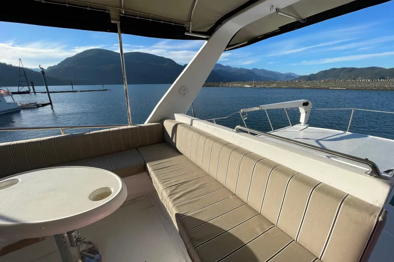 Hasta La Vista Yacht Photos Pics 1997 Symbol 48 Sportfish yacht with cushioned seating, scenic mountain and water view.