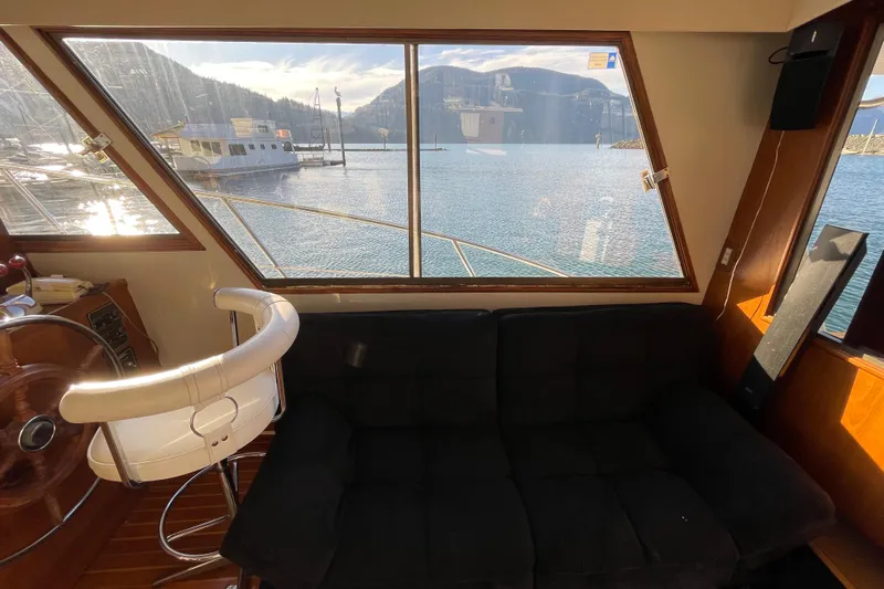 Hasta La Vista Yacht Photos Pics Interior view of 1997 Symbol 48 Sportfish yacht with scenic water and mountain backdrop.