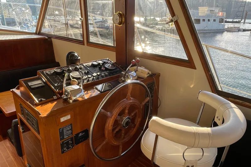 Hasta La Vista Yacht Photos Pics 1997 Symbol 48 Sportfish helm with wooden wheel and control panel, overlooking marina.