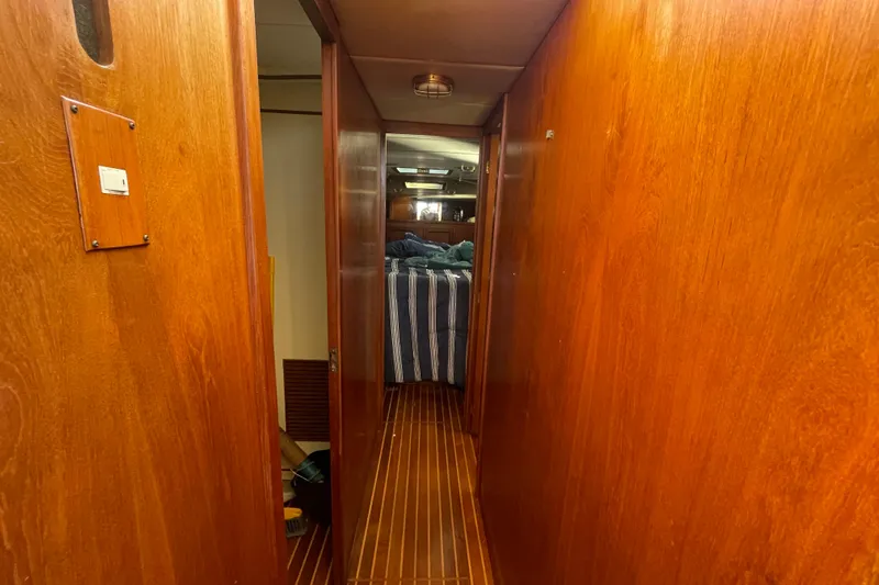 Hasta La Vista Yacht Photos Pics Hallway inside 1997 Symbol 48 Sportfish yacht with wooden paneling and striped bedding.