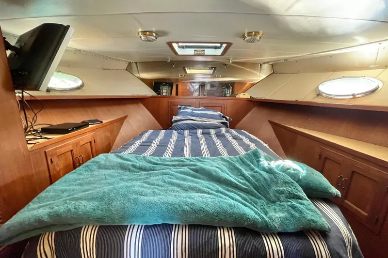 Hasta La Vista Yacht Photos Pics Cozy cabin interior of 1997 Symbol 48 Sportfish with striped bedding and porthole windows.