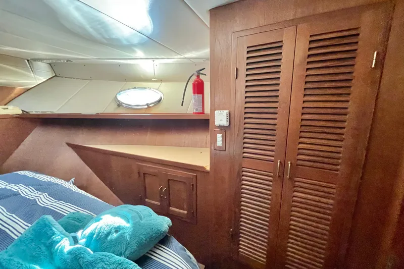 Hasta La Vista Yacht Photos Pics Cozy cabin interior of 1997 Symbol 48 Sportfish with wooden closet and porthole.