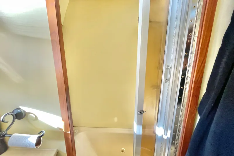 Hasta La Vista Yacht Photos Pics Shower area in 1997 Symbol 48 Sportfish boat with wooden trim and metal fixtures.