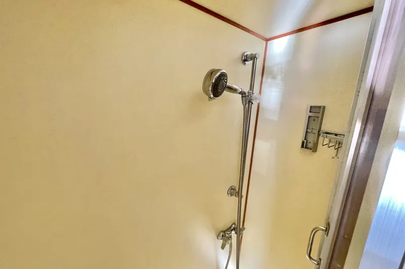 Hasta La Vista Yacht Photos Pics Shower area in 1997 Symbol 48 Sportfish yacht, featuring handheld showerhead and sleek design.