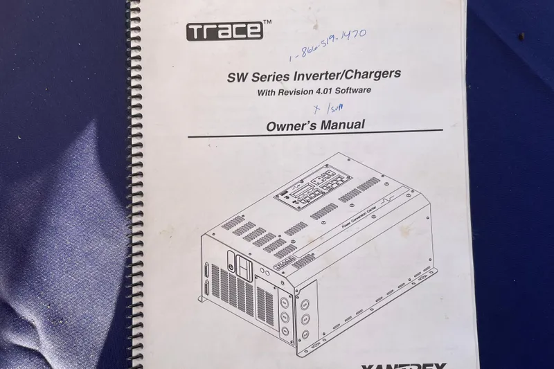 Hasta La Vista Yacht Photos Pics Owner's manual for Trace SW Series Inverter/Chargers on blue surface.