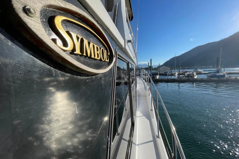 Hasta La Vista Yacht Photos Pics 1997 Symbol 48 Sportfish yacht docked in sunny marina with mountain backdrop.