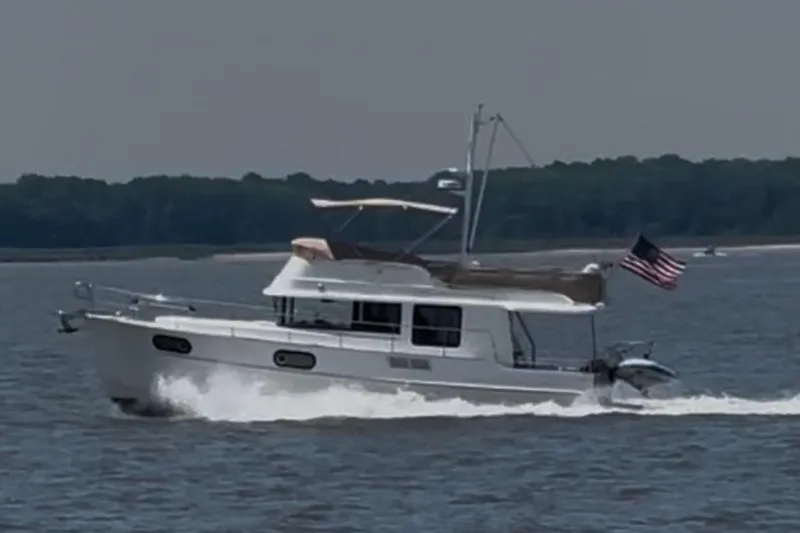  Yacht Photos Pics 2018 Beneteau Swift Trawler 44 cruising on a calm lake with an American flag.