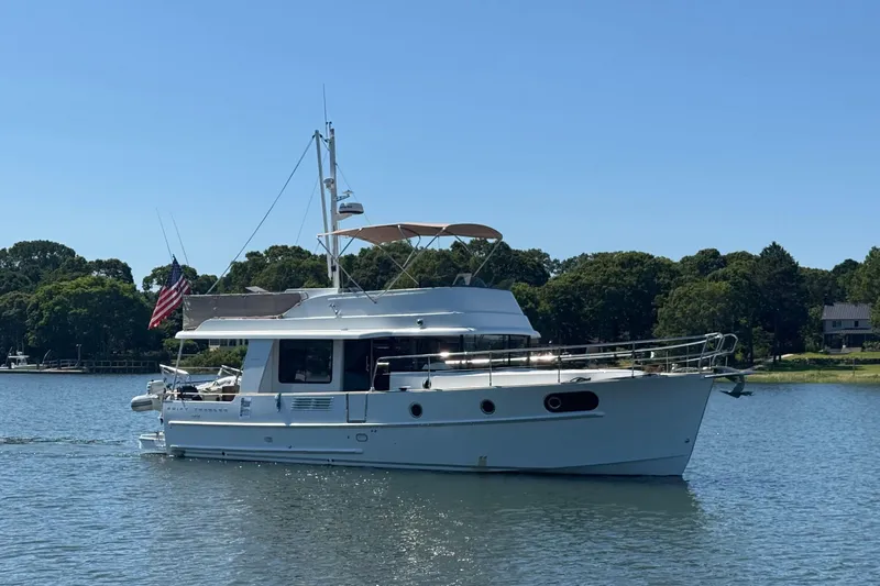  Yacht Photos Pics 2018 Beneteau Swift Trawler 44 cruising on a serene lake with lush greenery.